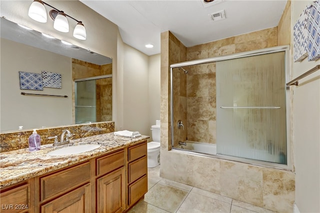 full bathroom featuring enclosed tub / shower combo, vanity, tile patterned flooring, and toilet