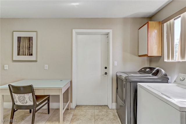 washroom with cabinets, light tile patterned floors, and washing machine and clothes dryer