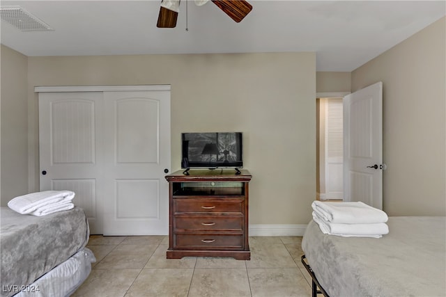 tiled bedroom featuring ceiling fan and a closet