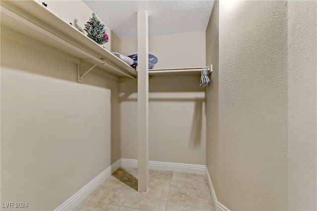 walk in closet with light tile patterned flooring