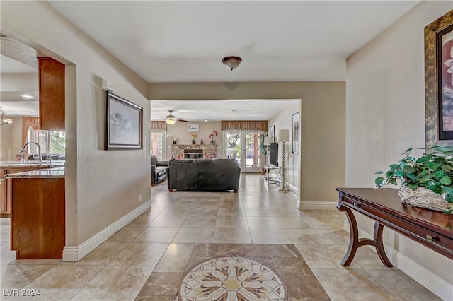 tiled foyer entrance with ceiling fan and sink