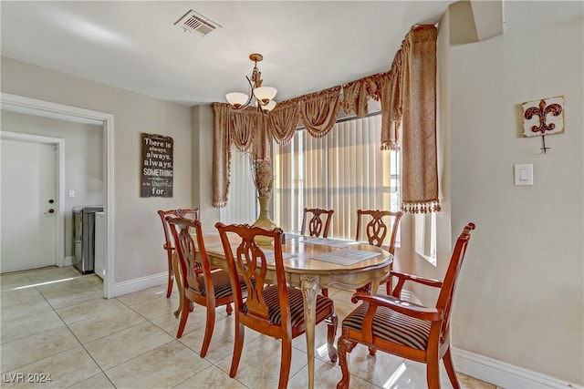 tiled dining space featuring an inviting chandelier