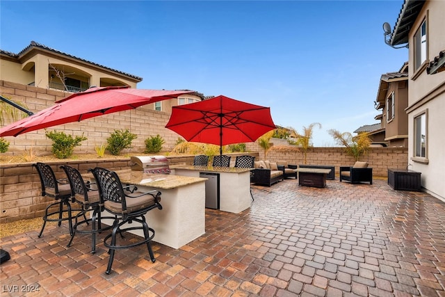 view of patio / terrace featuring an outdoor kitchen, a bar, and grilling area