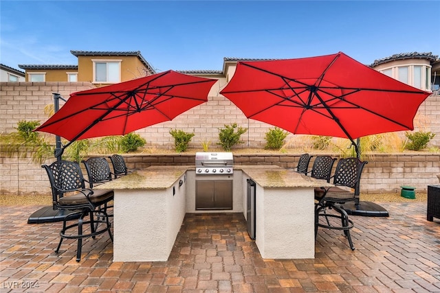 view of patio featuring an outdoor bar, area for grilling, and exterior kitchen