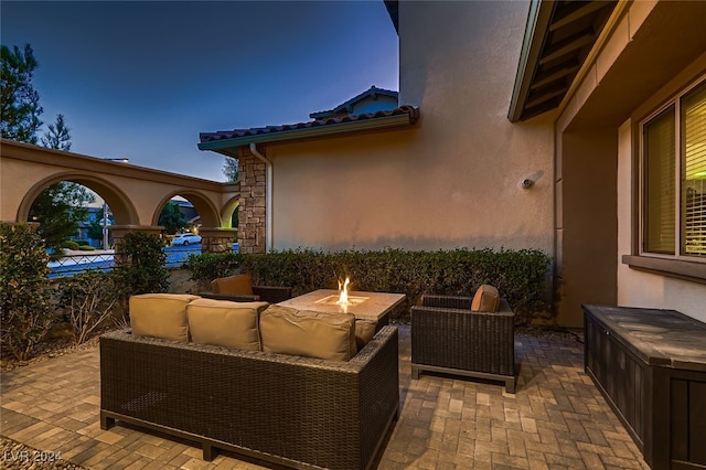 patio terrace at dusk featuring an outdoor living space