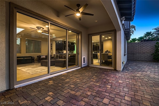 patio terrace at dusk featuring ceiling fan