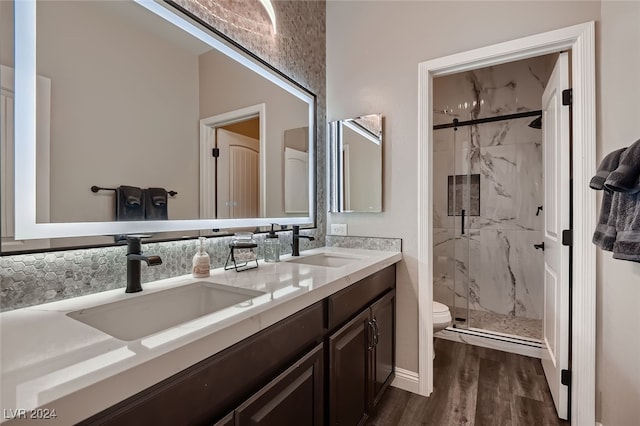 bathroom featuring hardwood / wood-style flooring, a shower with door, vanity, and toilet