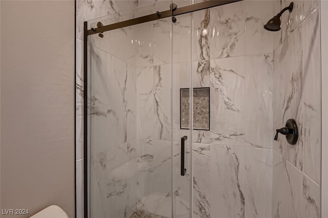 bathroom featuring toilet and an enclosed shower