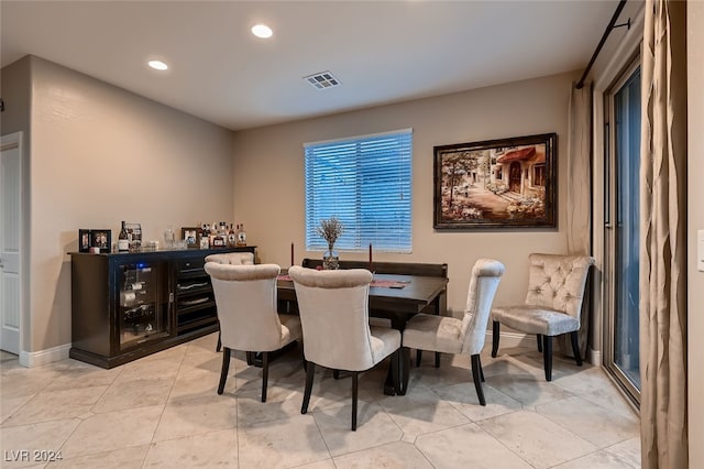 dining space with light tile patterned floors and bar