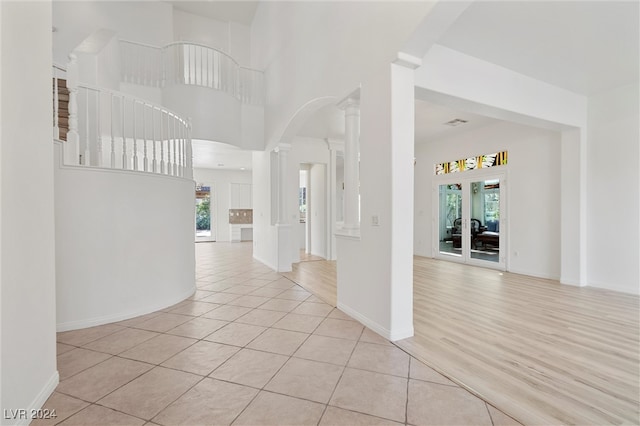 foyer entrance with decorative columns, light hardwood / wood-style floors, and plenty of natural light