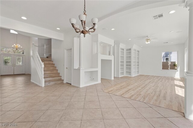 interior space featuring ceiling fan with notable chandelier, ornate columns, and light hardwood / wood-style flooring