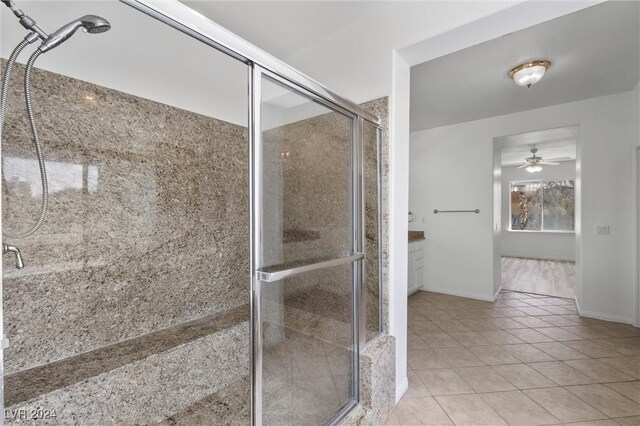 bathroom featuring tile patterned flooring, ceiling fan, and a shower with door