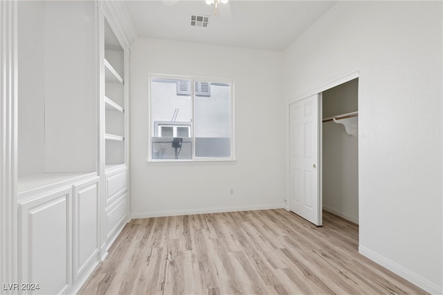 unfurnished bedroom with light hardwood / wood-style flooring and a closet