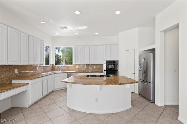 kitchen featuring backsplash, stone counters, stainless steel appliances, and white cabinets