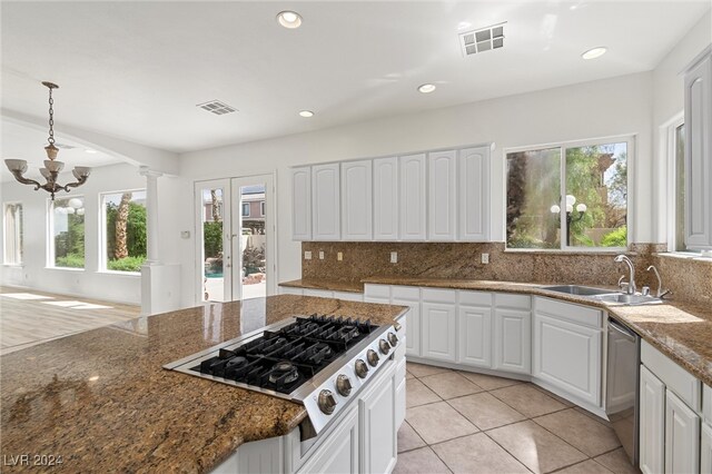 kitchen with plenty of natural light, dark stone countertops, and white cabinets