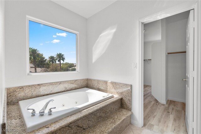 bathroom featuring tiled bath and hardwood / wood-style flooring