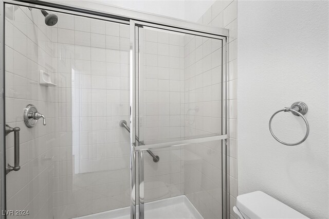 bathroom featuring an enclosed shower and toilet