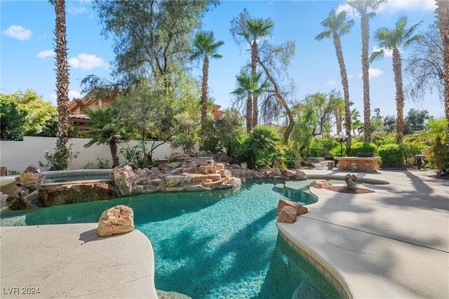 view of swimming pool with a patio and an in ground hot tub