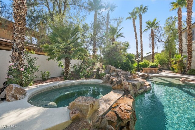 view of pool featuring an in ground hot tub