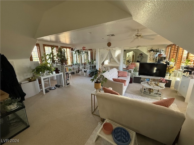 living room with a textured ceiling, light colored carpet, and ceiling fan