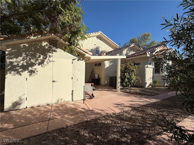 rear view of property with a patio area and cooling unit