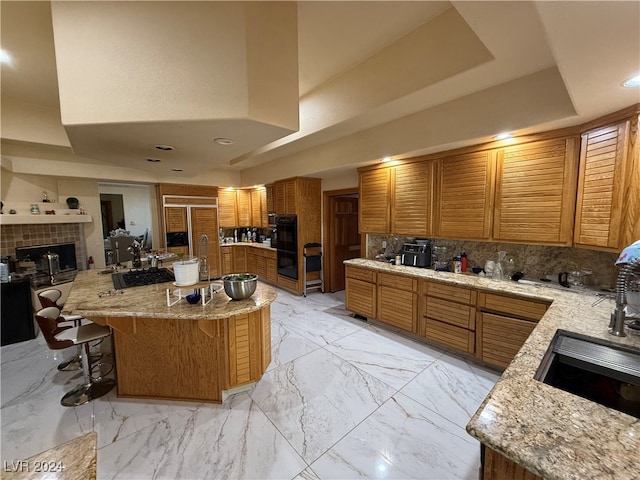 kitchen with a breakfast bar, tasteful backsplash, a center island, and a tray ceiling