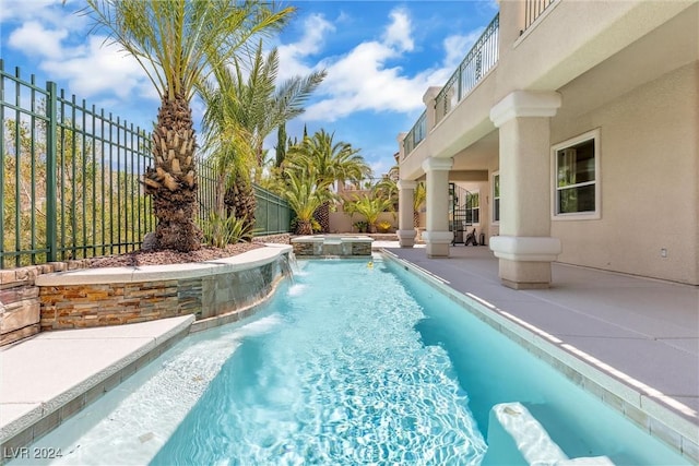 view of pool featuring an in ground hot tub, pool water feature, and a patio area