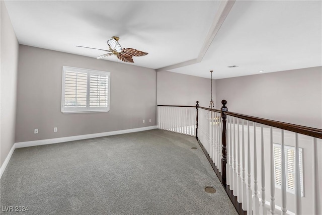 empty room featuring carpet and ceiling fan with notable chandelier