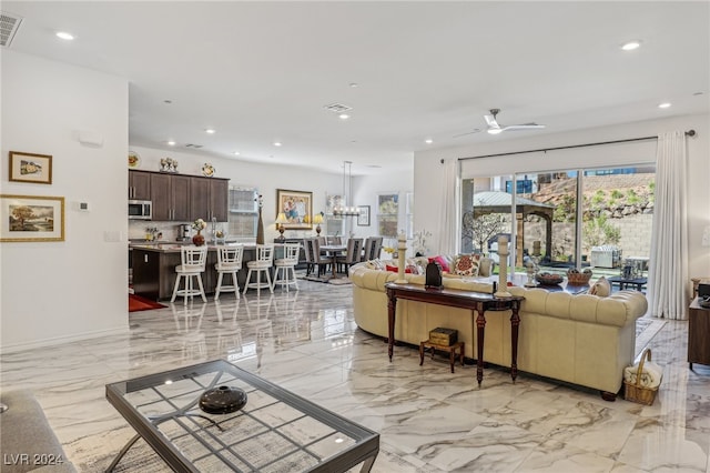 living room featuring ceiling fan with notable chandelier