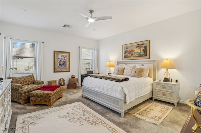 bedroom with ceiling fan, carpet floors, and multiple windows