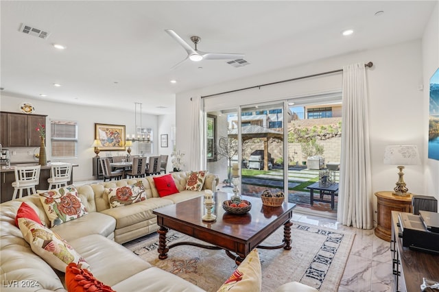 living room featuring ceiling fan and a healthy amount of sunlight