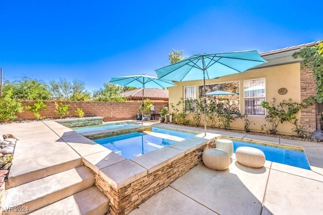 view of pool featuring a patio area and an in ground hot tub