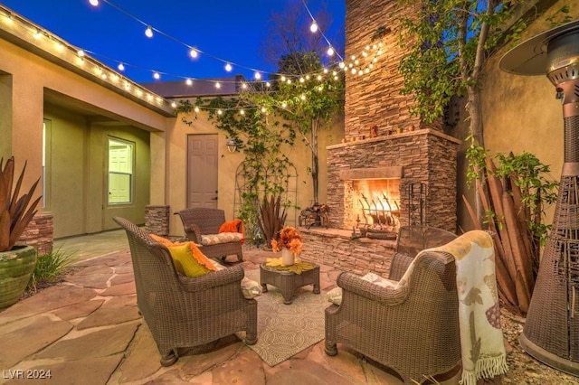 patio at twilight with an outdoor living space with a fireplace