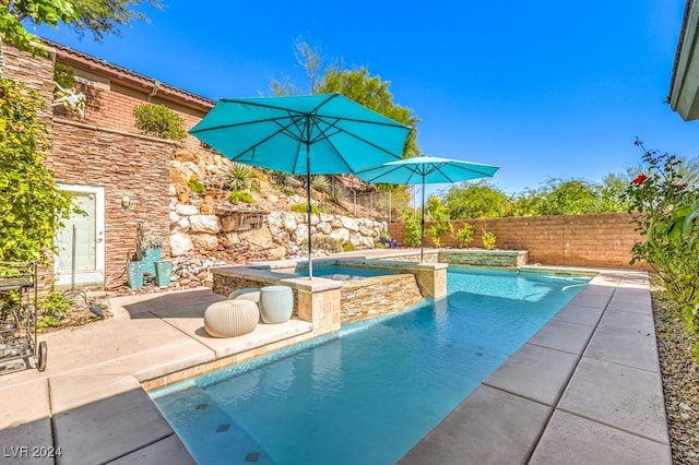 view of pool featuring a patio area and an in ground hot tub