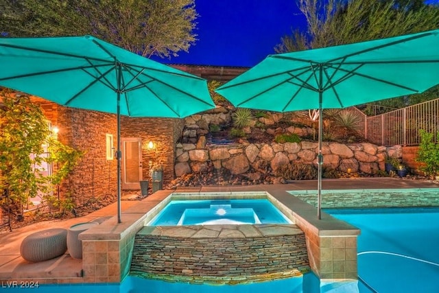 pool at twilight with an in ground hot tub