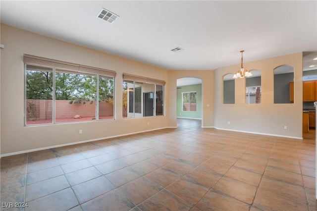 unfurnished living room with light tile patterned floors and a chandelier