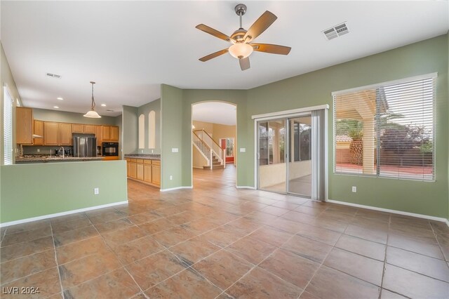 unfurnished living room featuring ceiling fan and light tile patterned flooring