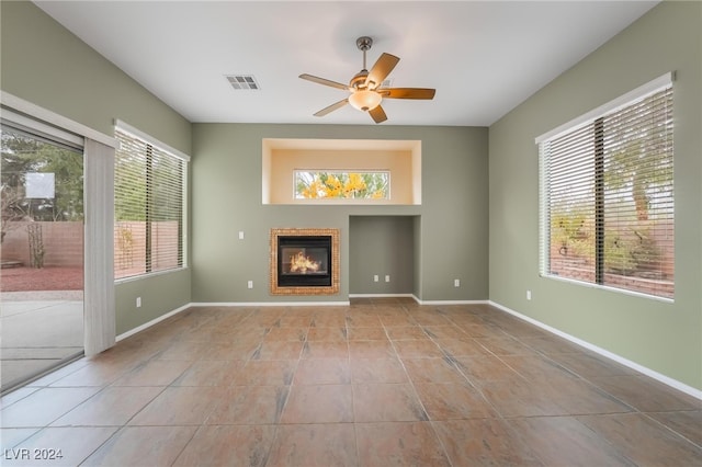 unfurnished living room featuring ceiling fan and light tile patterned flooring