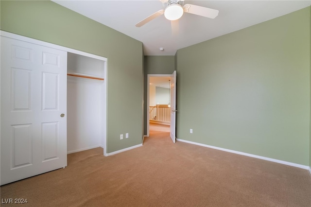 unfurnished bedroom featuring light carpet, a closet, and ceiling fan