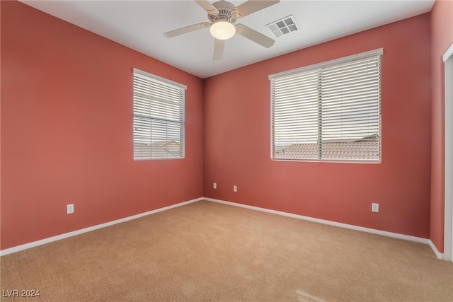 carpeted spare room with ceiling fan