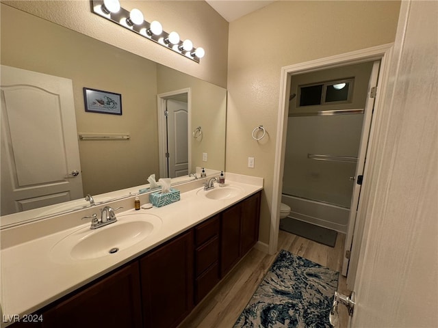 full bathroom featuring enclosed tub / shower combo, hardwood / wood-style floors, vanity, and toilet