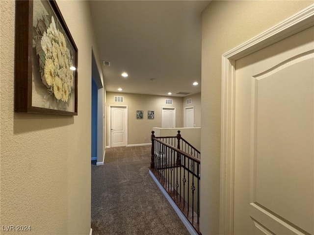 hall with dark colored carpet