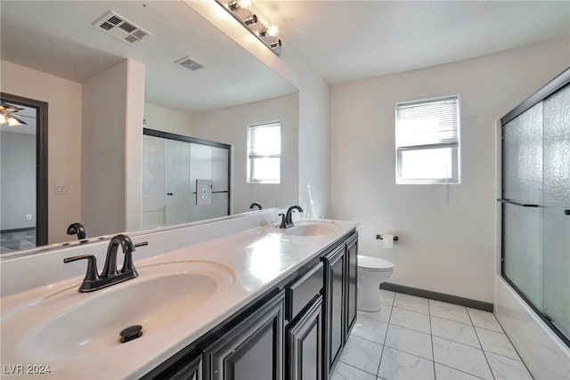 full bathroom featuring enclosed tub / shower combo, vanity, toilet, and a healthy amount of sunlight