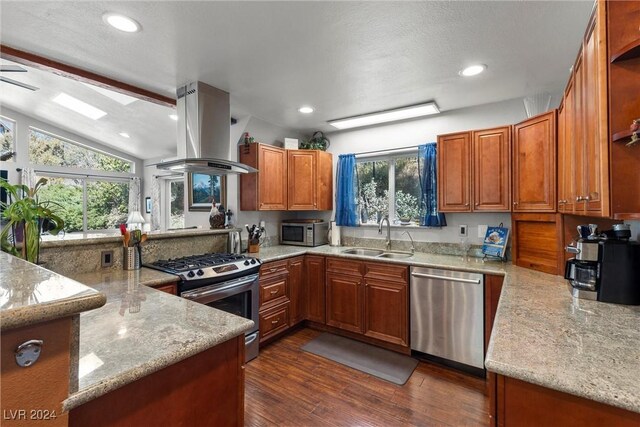 kitchen with sink, appliances with stainless steel finishes, dark hardwood / wood-style flooring, light stone counters, and island exhaust hood