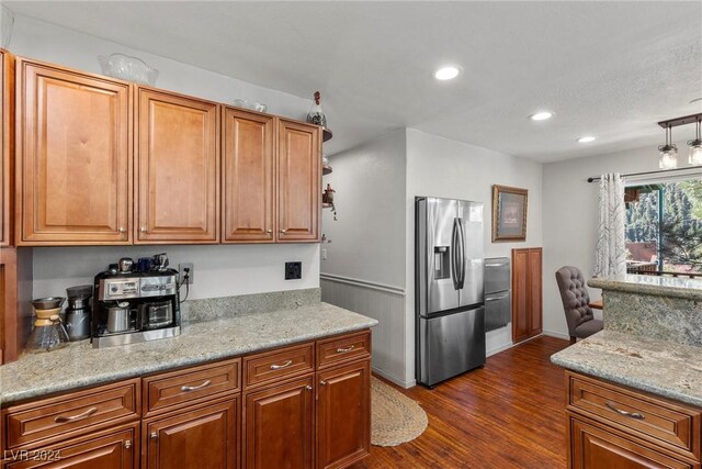 kitchen featuring a textured ceiling, light stone counters, dark hardwood / wood-style floors, and stainless steel refrigerator with ice dispenser