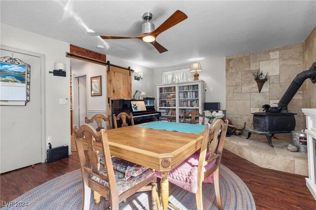 dining space with a textured ceiling, dark hardwood / wood-style floors, a wood stove, and tile walls