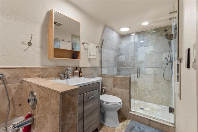 bathroom with vanity, an enclosed shower, tile walls, and toilet