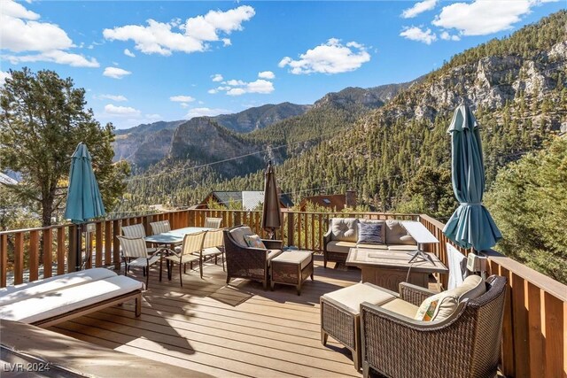 wooden deck featuring outdoor lounge area and a mountain view