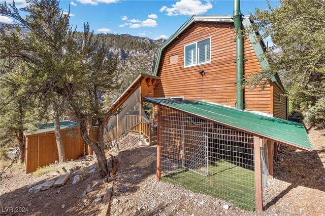 view of side of home featuring an outbuilding and a mountain view