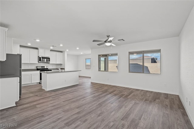 kitchen featuring appliances with stainless steel finishes, light hardwood / wood-style floors, white cabinets, ceiling fan, and a kitchen island with sink